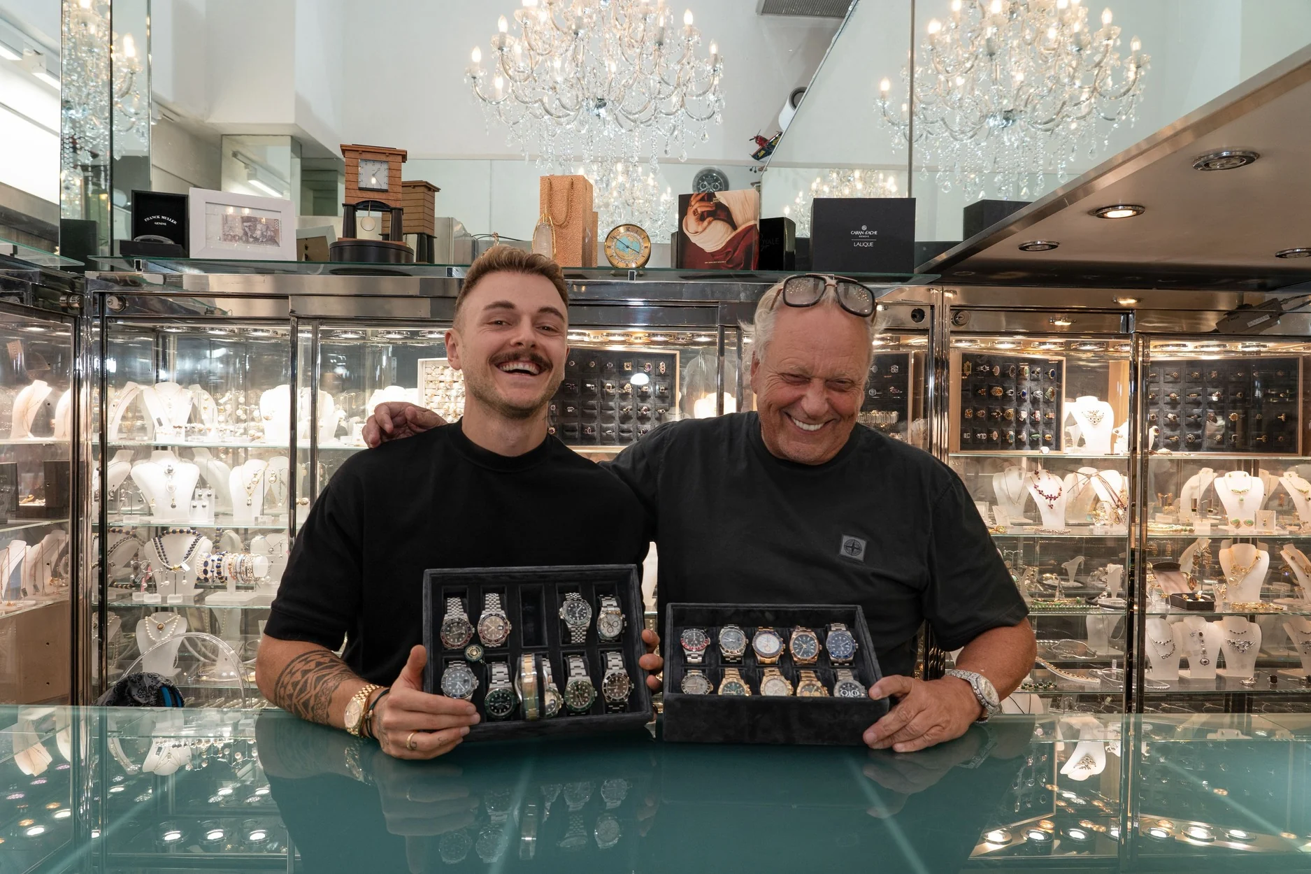 Klaus Gawron (rechts) mit seinem Sohn (links) in seinem Geschäft Juwelier FineArt in Düsseldorf. Beide halten boxen mit jeweils mindestens 10 Luxus-Uhren vor sich